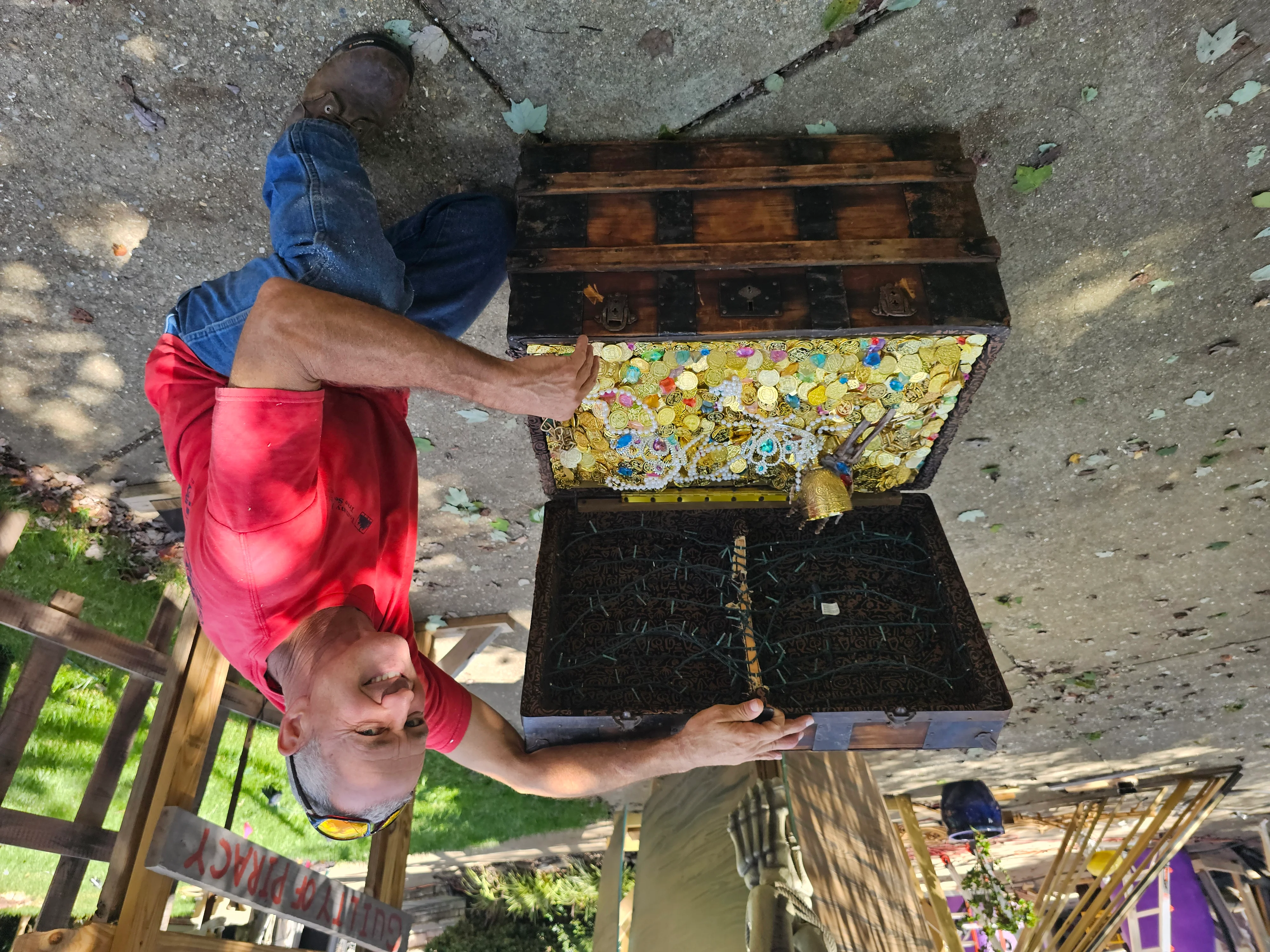 Worker holding open a weathered wooden steamer trunk with decorative interior lining